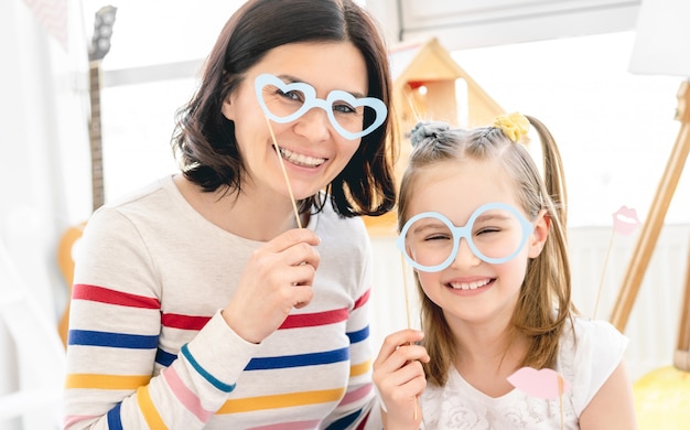 Mother and daughter with stick glasses