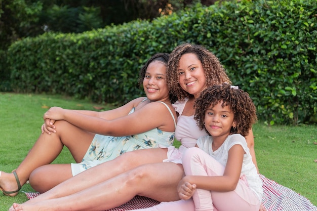 Mother and daughters hanging out at a picnic in the park