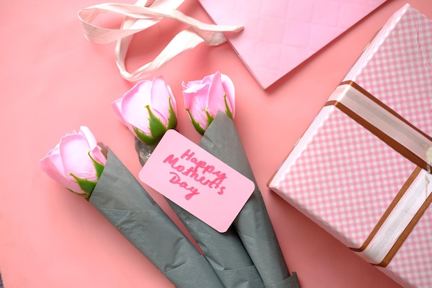 Подарок на день матери и розовый цветок розы на столе