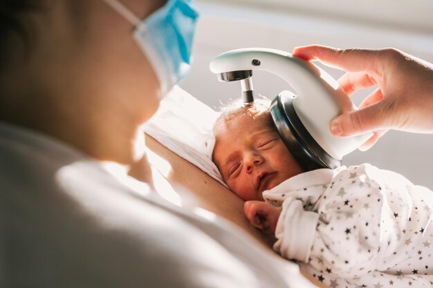 Mother doing ABR screening to baby in hospital