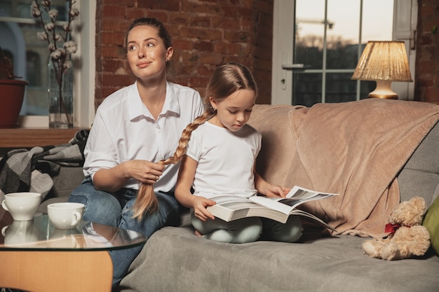 Mother doing braids on her daughter's hair