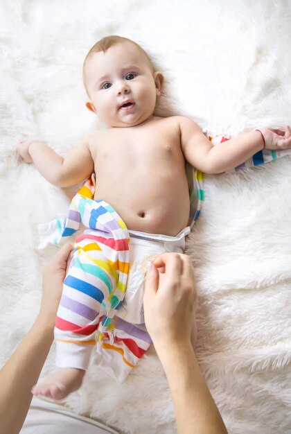 Mother dresses her little baby Selective focus