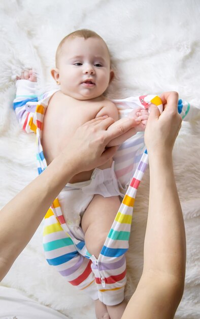 Mother dresses her little baby Selective focus