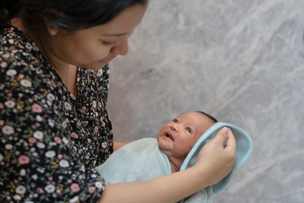 写真 シャワーと入浴後に赤ちゃんの髪を乾かす母親