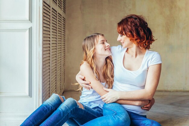 Photo mother embracing daughter at home