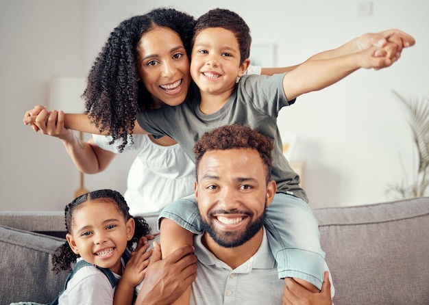 Mother father and children in family portrait and bonding in house home or hotel living room Smile happy and fun girl boy or kids playing airplane game with man mexican woman or parents on sofa