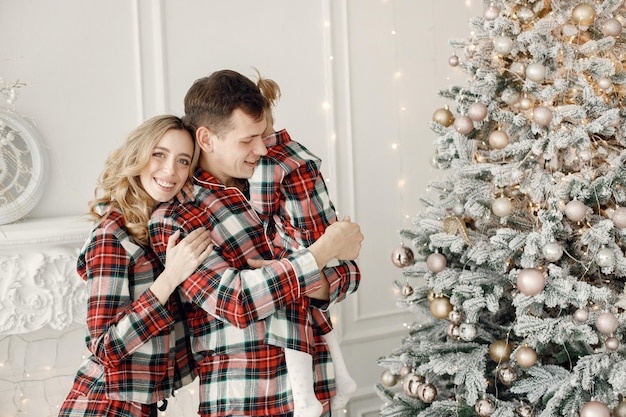 Mother father and daughter hugging near Christmas tree