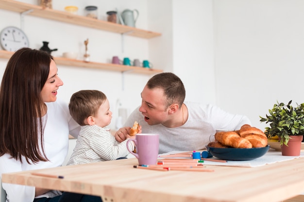 Foto madre e padre che mangiano con il bambino in cucina