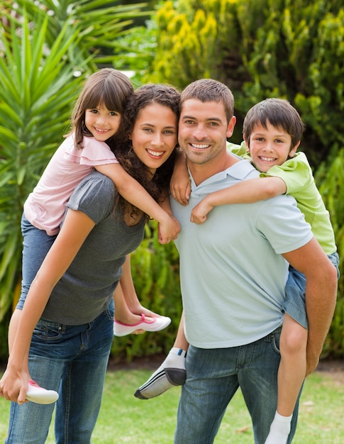 Mother and father giving children a piggyback