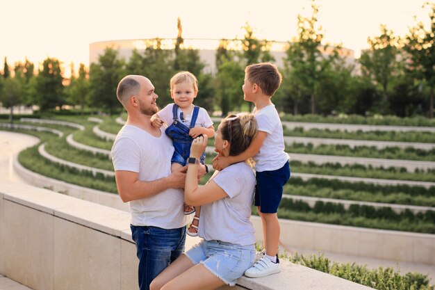 Madre e padre che giocano nel parco con i loro figli