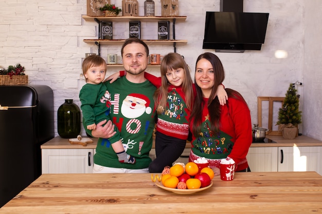 Mother, father, son and daughter on Christmas morning in the kitchen