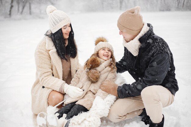 mother father and their little daughter playing outdoors at winter day