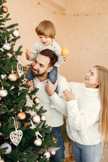 Mother father and their son decorating Christmas tree at home