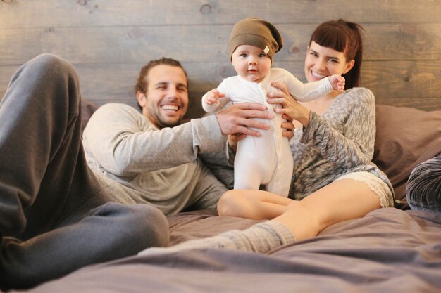 A mother father and young baby playing at home