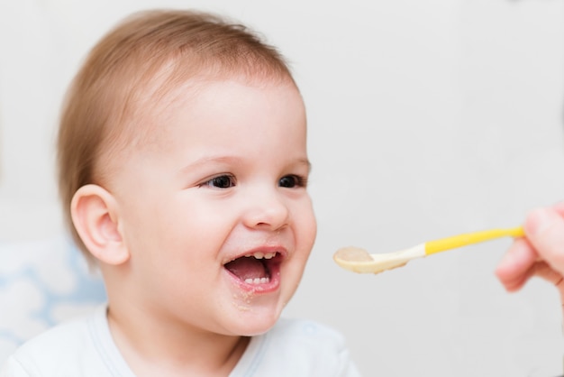 Mother feeding her baby breast porridge day