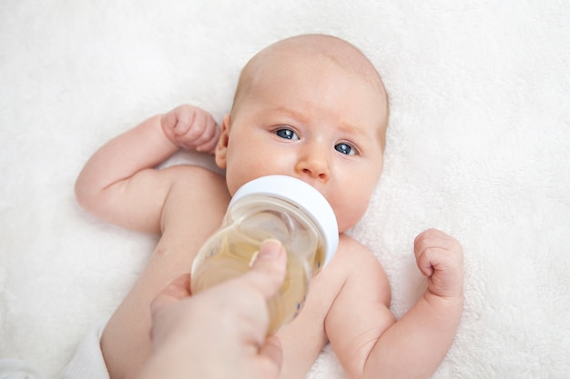 Mother feeding newborn baby from the bottle