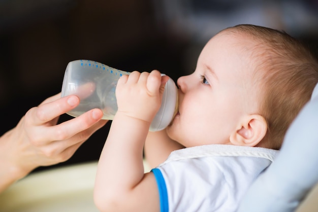 Mother feeds baby from a bottle of milk