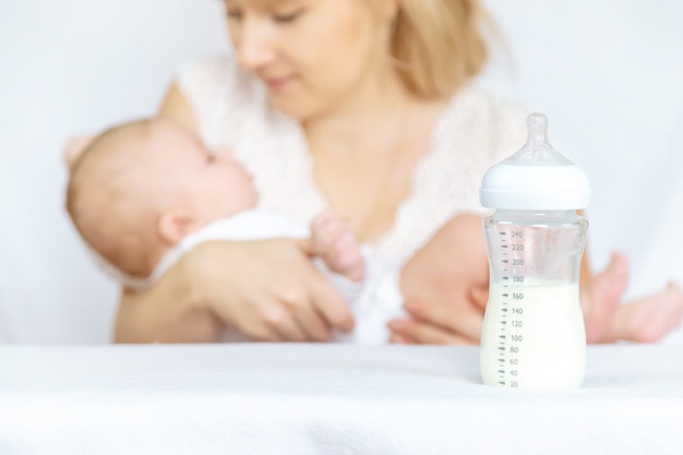 Mother feeds the baby from a bottle