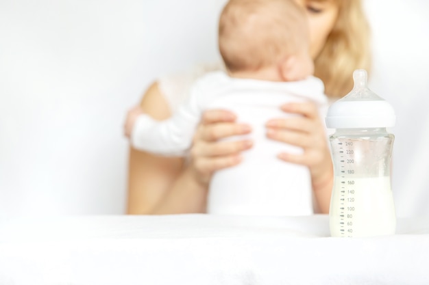 Photo mother feeds the baby from a bottle