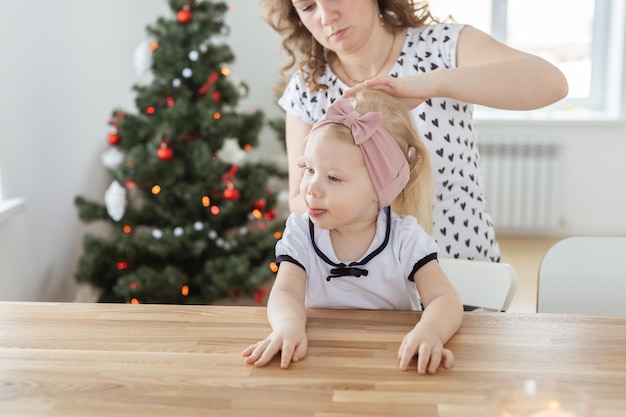 Mother fixing her daughter's cochlear implant hearing aid deafness and diversity concept Innovative technologies in treatment of deafness