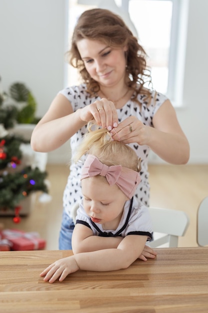 Mother fixing her daughter's cochlear implant hearing aid diversity concept Innovative medical technologies