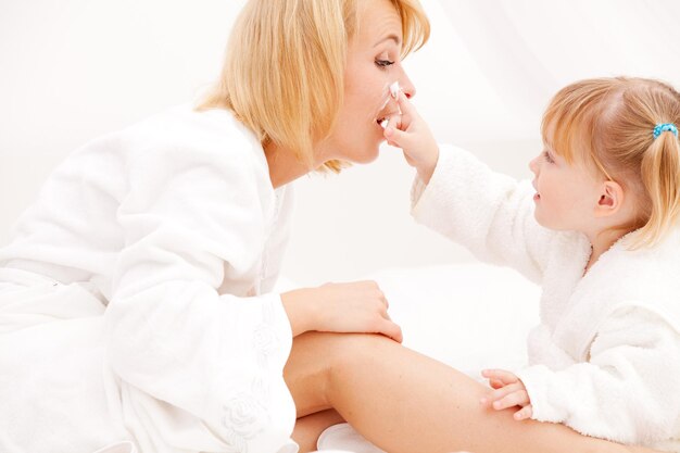 Foto madre e bambina che applicano la crema