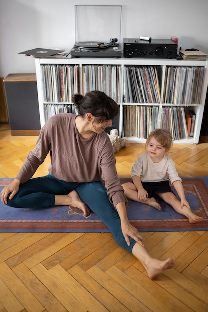 Photo mother and girl stretching full shot