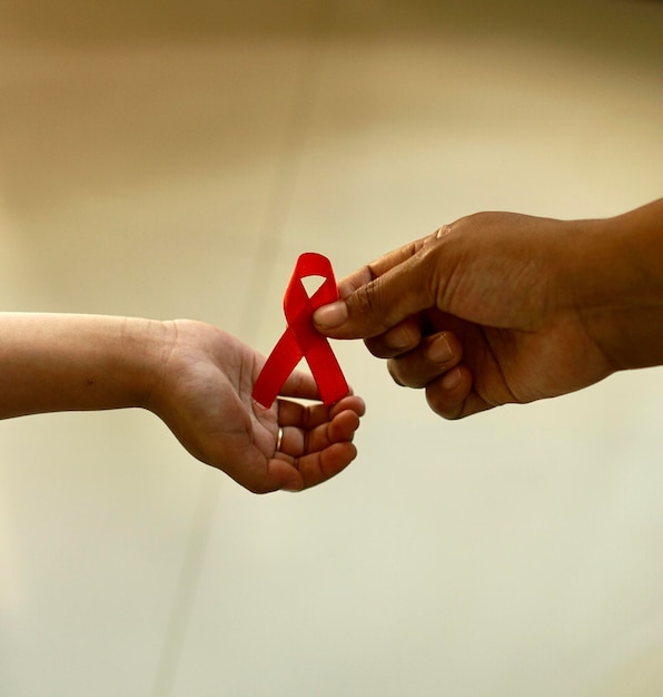 Mother giving aids ribbon to child