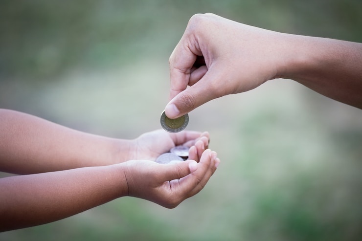Photo mother giving coin to child as saving money concept in vintage color tone