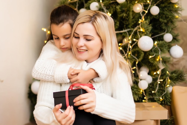 Mother giving her daughter christmas gift.