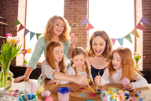 mother and grandmother helping children to draw