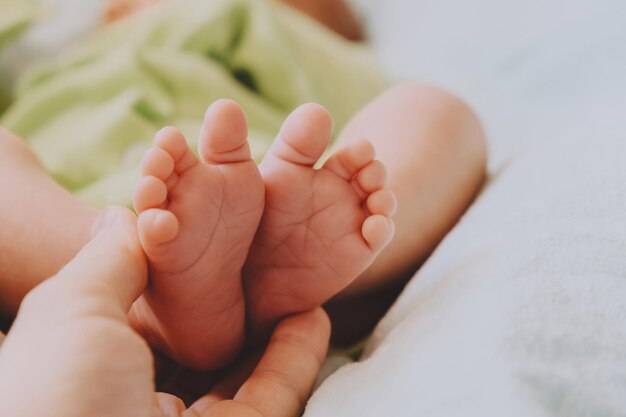 Mother hand holds cute newborn baby feet