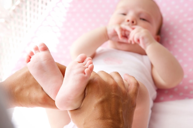 Mother hands holding cute baby feet