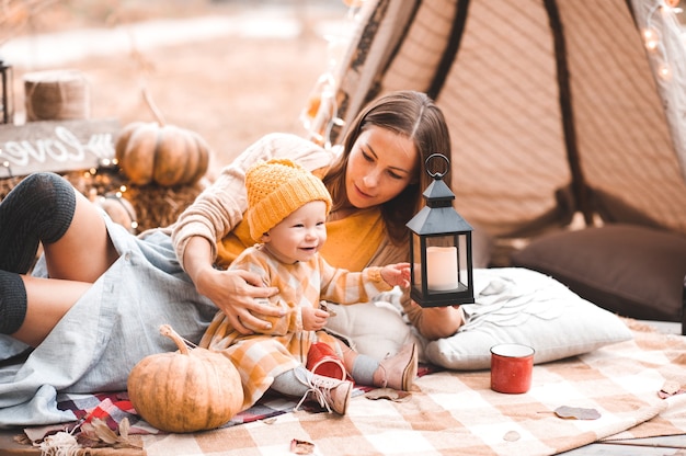 Mother having rest with kid daughter over autumn decorations