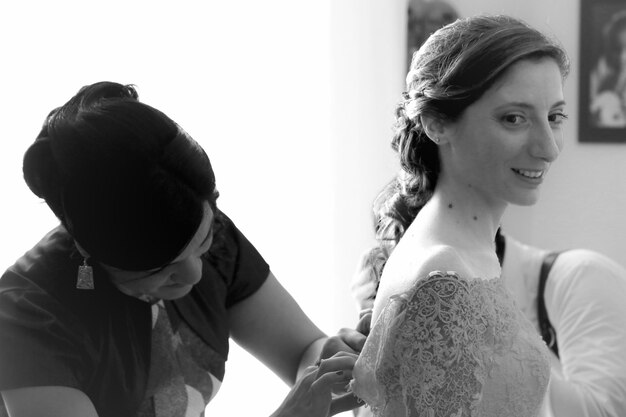 Photo mother helping bride with wedding dress