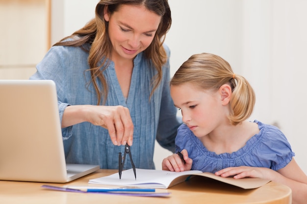 Mother helping her daughter doing her homework