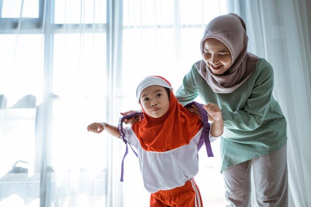 Mother helping her daughter preparing school