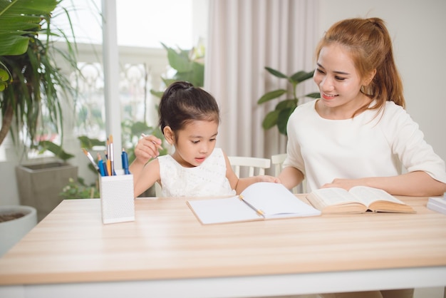 Mother helping her little child with homework