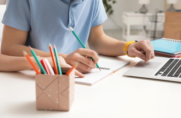 Mother helping her teenager son with homework at desk closeup