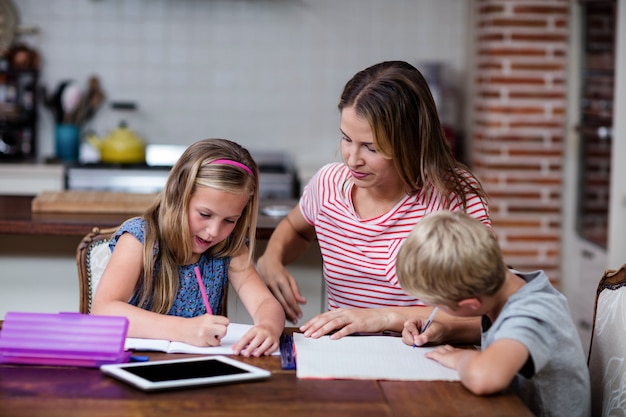 Mother helping kids with their homework