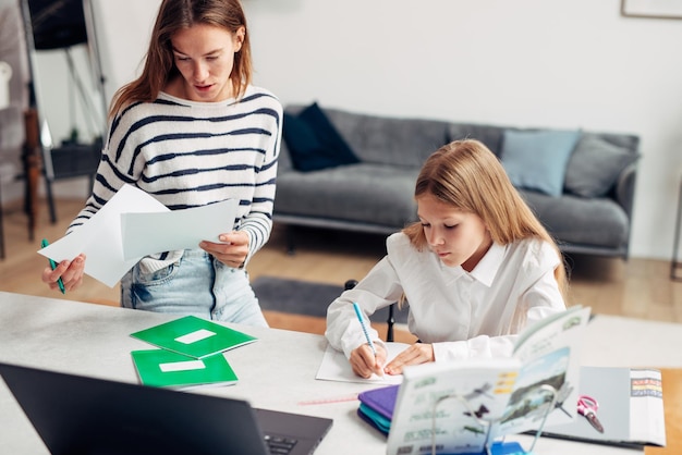 Mother helps her daughter with her homework