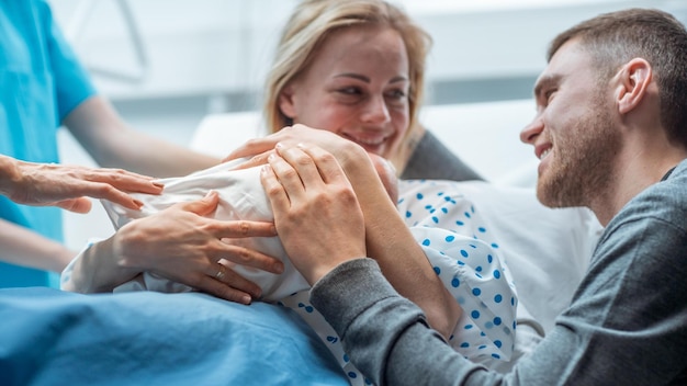 A mother and her baby are looking at the camera and smiling.