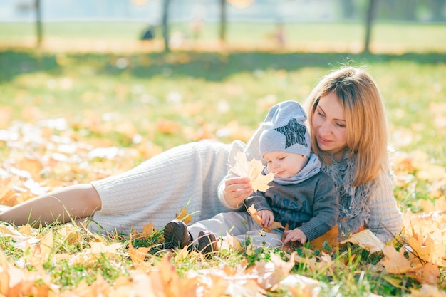 어머니와 그녀의 귀여운 아기 가을 공원에.