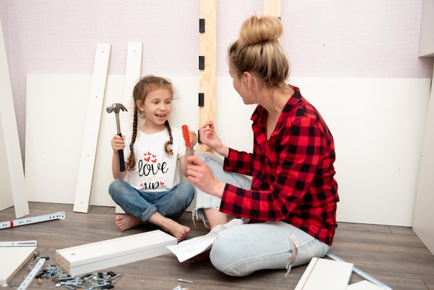 A mother and her daughter assemble the bed