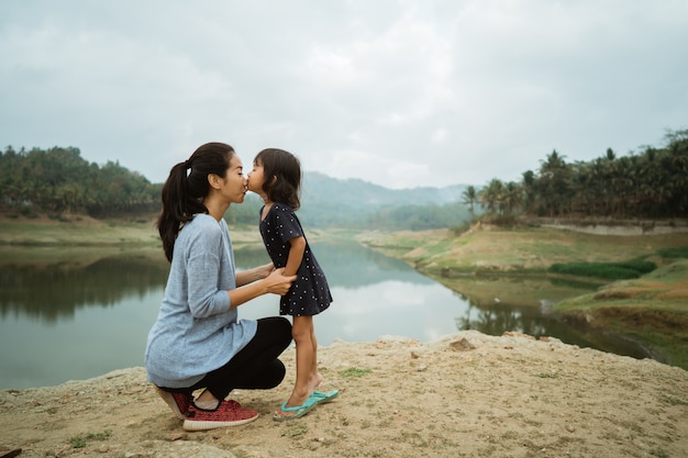 A mother and her daughter kissing each other symbol of love