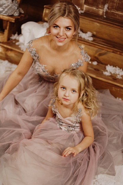 Mother and her daughter in pink dresses 