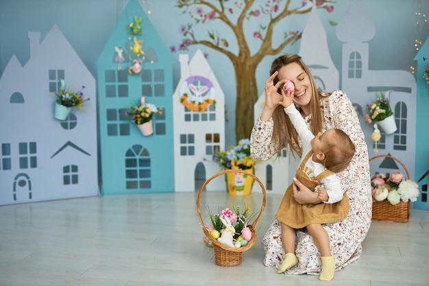 Mother and her daughter with painting eggs