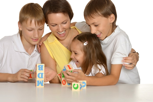 Mother and her kids playing with cubes isolated on white