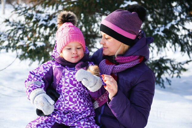 Mother and her little daughter enjoying beautiful winter day outdoors.