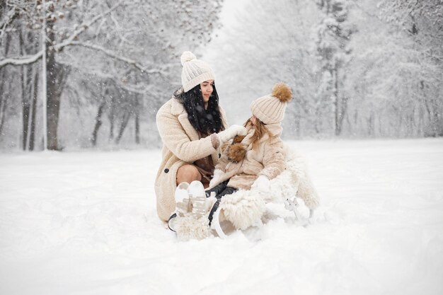 Mother and her little daughter playing outdoors at winter day